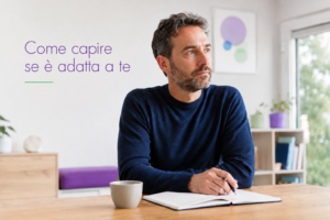 Persona adulta in uno studio accogliente e luminoso, in un momento di riflessione davanti a un tavolo con quaderno e penna, immagine per un articolo sulla Kinesiologia Sistematica.